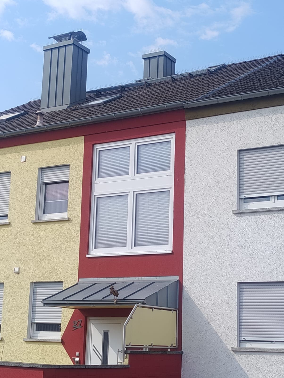 Neu eingedecktes Steildach mit anthrazitfarbener Fassadenverkleidung an einem Wohnhaus